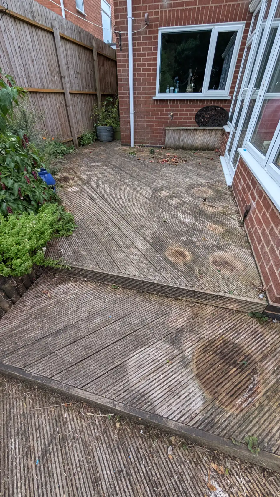 Timber garden decking before cleaning, darkened by algae and general weathering