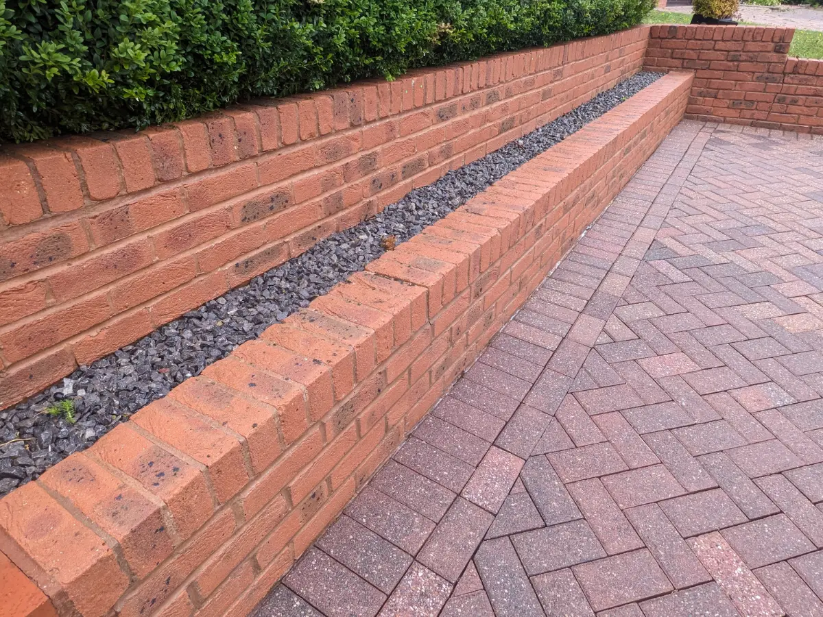 The same paved path and wall area after Restorra cleaning