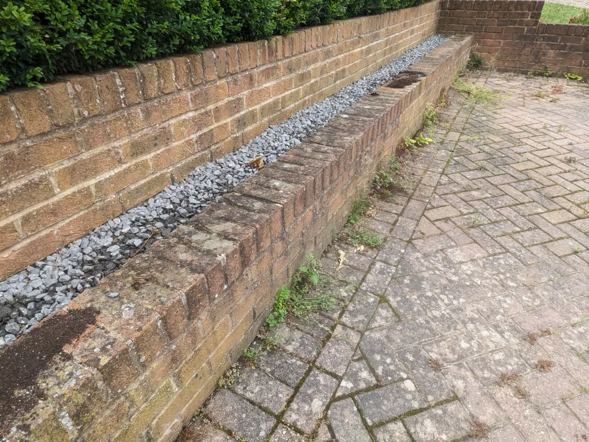 Paved path and wall area before Restorra cleaning