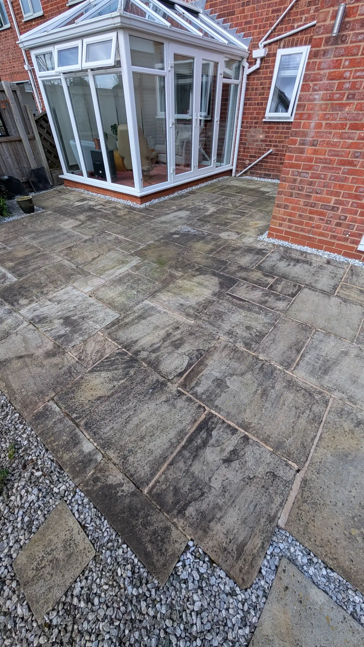 Indian sandstone patio in Penwortham before cleaning, with algae staining across the flags