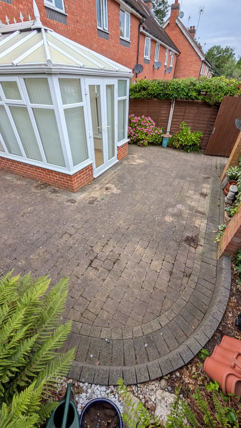 Block-paved patio and path before pressure washing, with dirt and staining across the surface