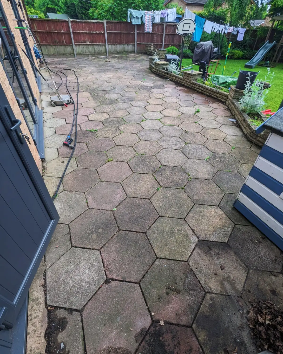 Concrete paving slabs in Croston before cleaning, with moss growing in the joints